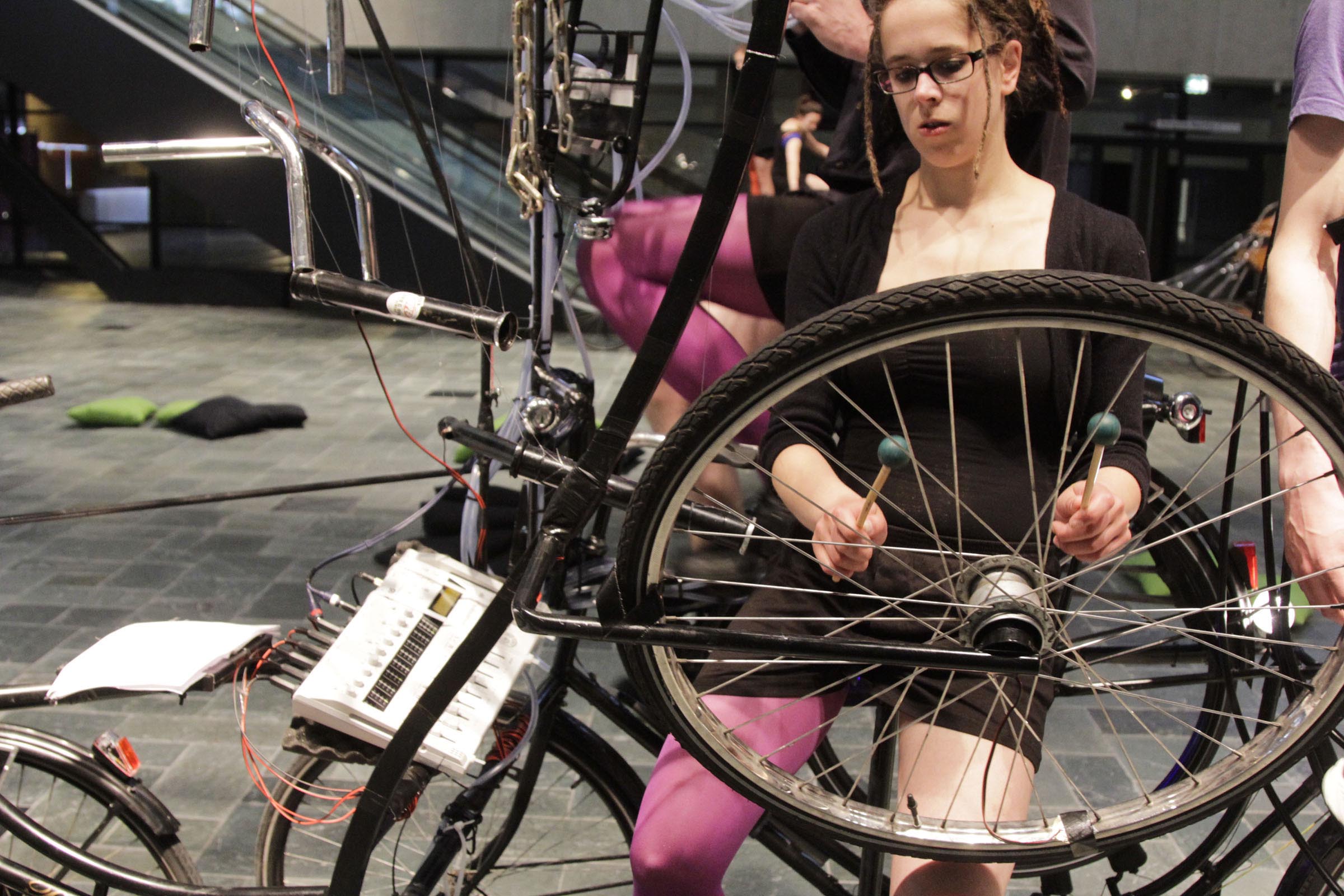 Claudia Hansen playing percussion on a bike installation during the Music Theater performance Cyclophonia at De Doelen Rotterdam